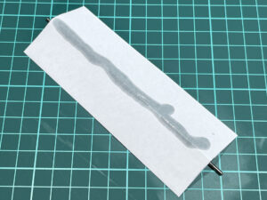 へり落とし研ぎ方：研ぎ棒の上にコピー用紙を置いてオイルを塗りる