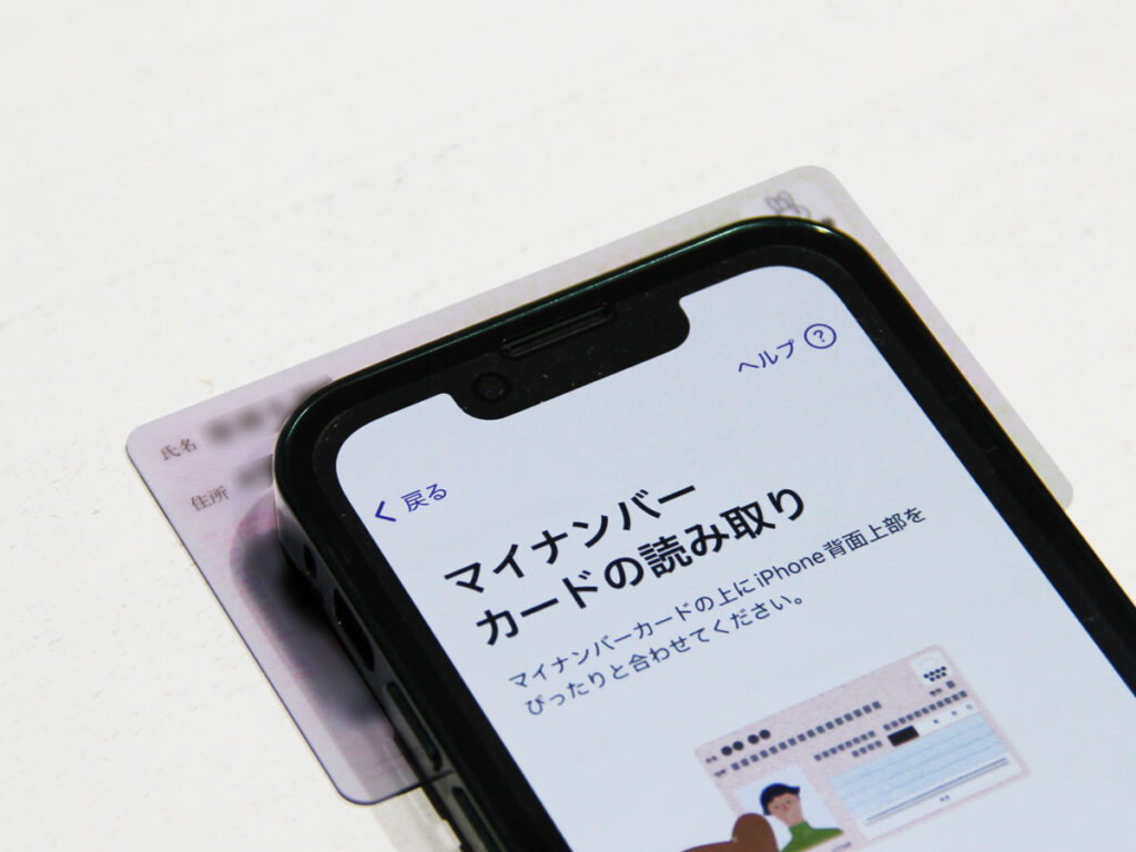 マイナンバーカードをiPhoneで読み取っている様子