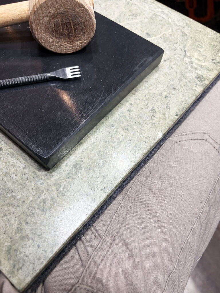 膝の上に御影石を載せてレザークラフトの作業をする振動対策の方法