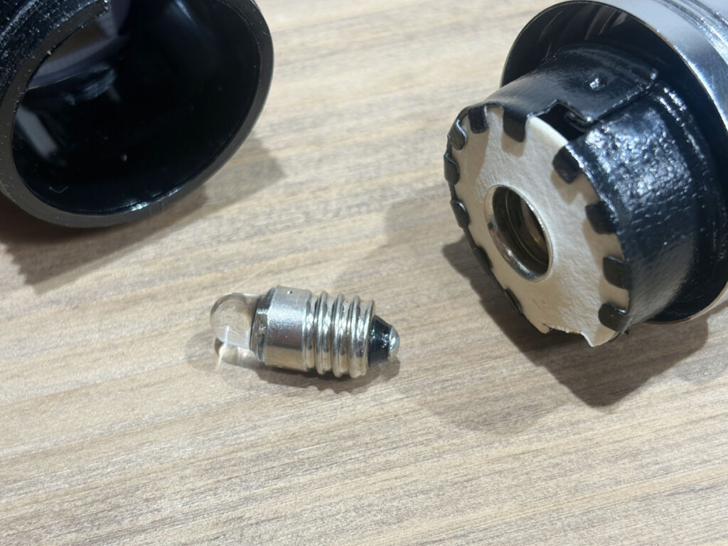 旧M-100に取り付けていたLED電球と、取り外したレンズヘッド。もとは豆電球だった